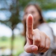 Blurred image of a woman touching or pointing finger at you