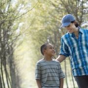a man and a young boy walking down an avenue